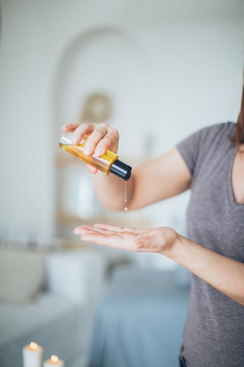 Free A Person Pouring a Massage Oil on It's Hand Stock Photo