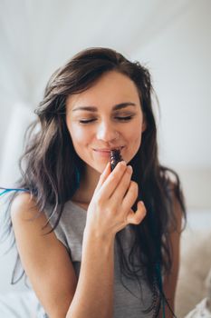年轻女子在室内闻着香熏瓶的香味，露出了微笑