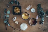 平铺的沐浴盐、蜡烛和树叶，非常适合营造舒缓的家庭水疗体验