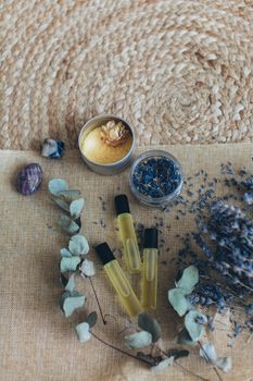 从顶视图看，芳香疗法将熏衣草、精油和水晶摆放在编织垫上