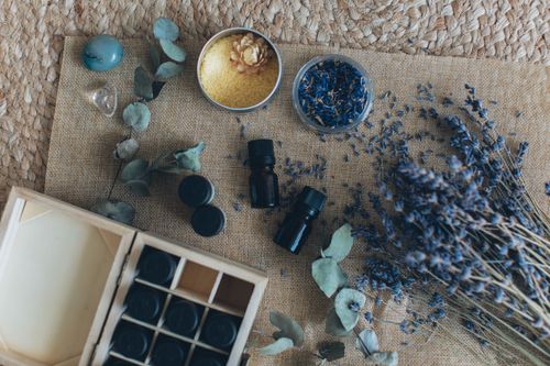 Free A flat lay displaying essential oils, dried lavender, and other aromatherapy items on a woven mat. Stock Photo