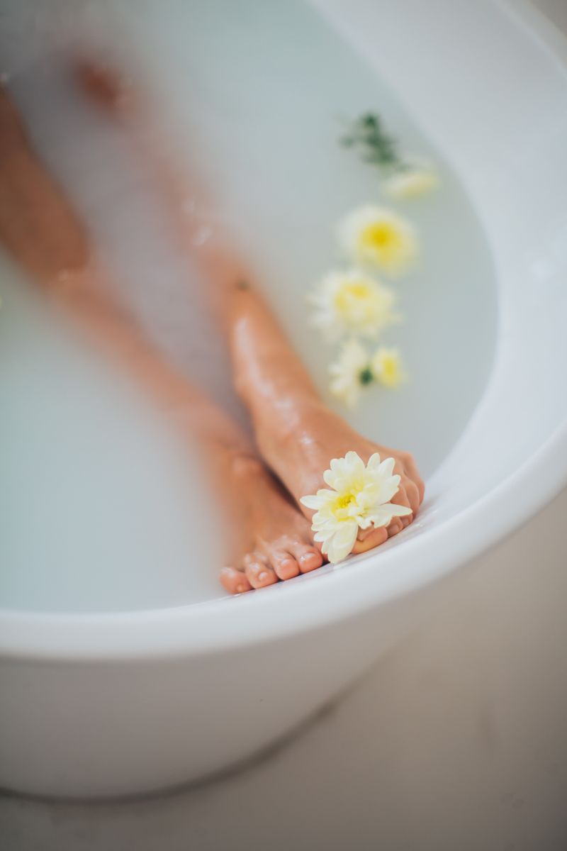 Feet soaking in a bathtub with flowers evoking relaxation