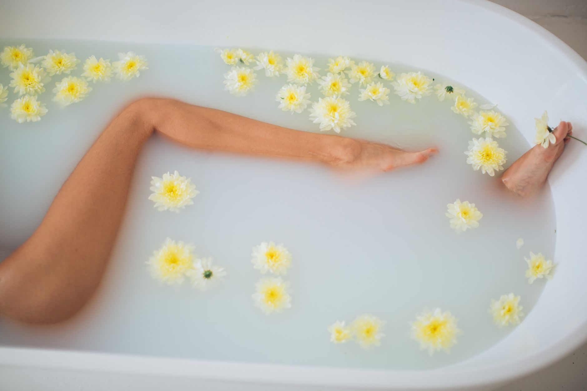 A serene bath with yellow flowers offering tranquility and relaxation.