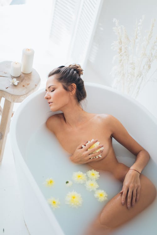 Nude Woman Lying in White Bathtub