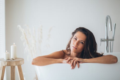 A Beautiful Woman Posing while in a Bathtub