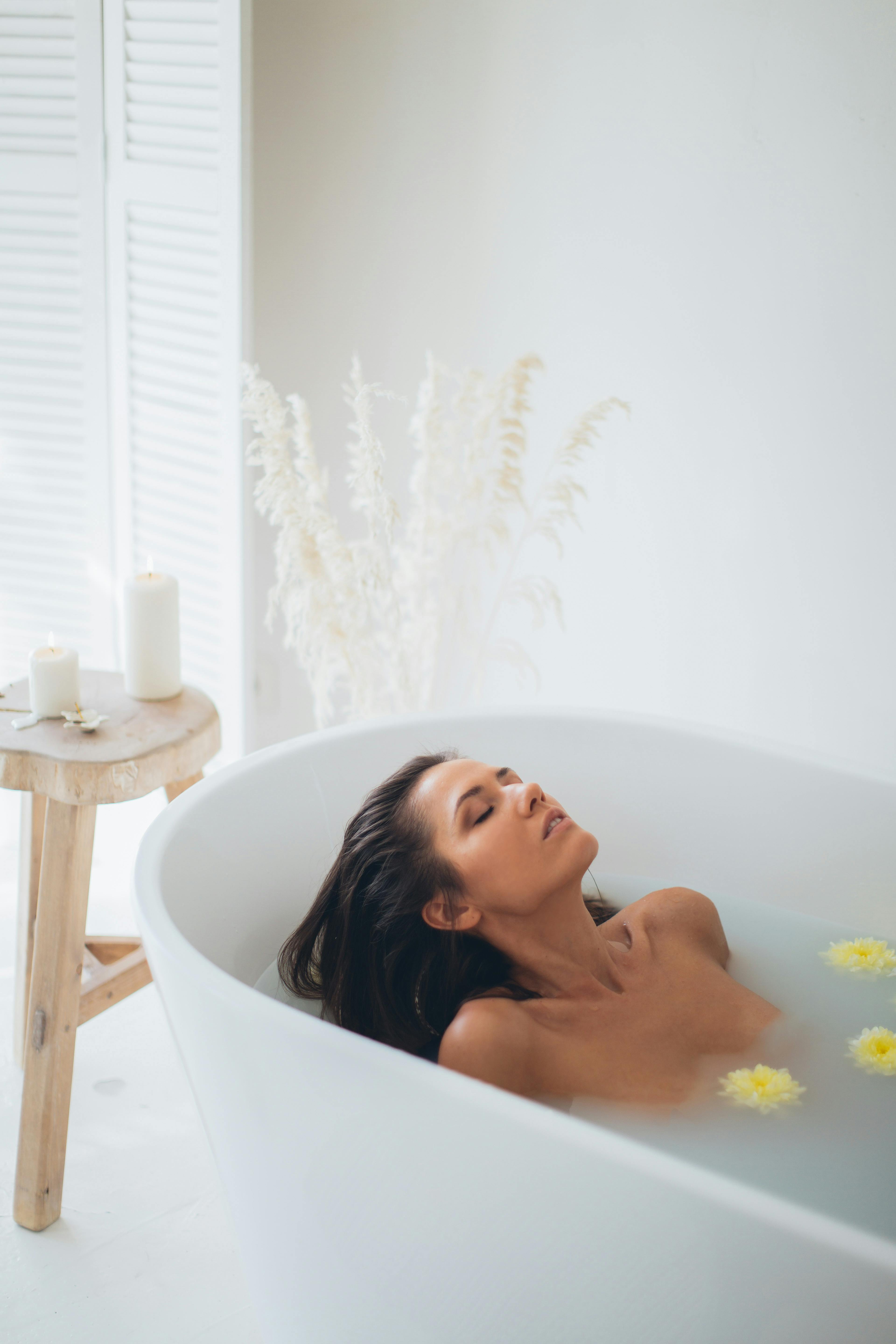 woman lying in bathtub with water