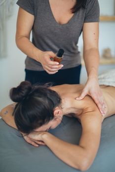 一位女士在水疗中心接受舒缓的背部按摩，以放松身心、促进健康