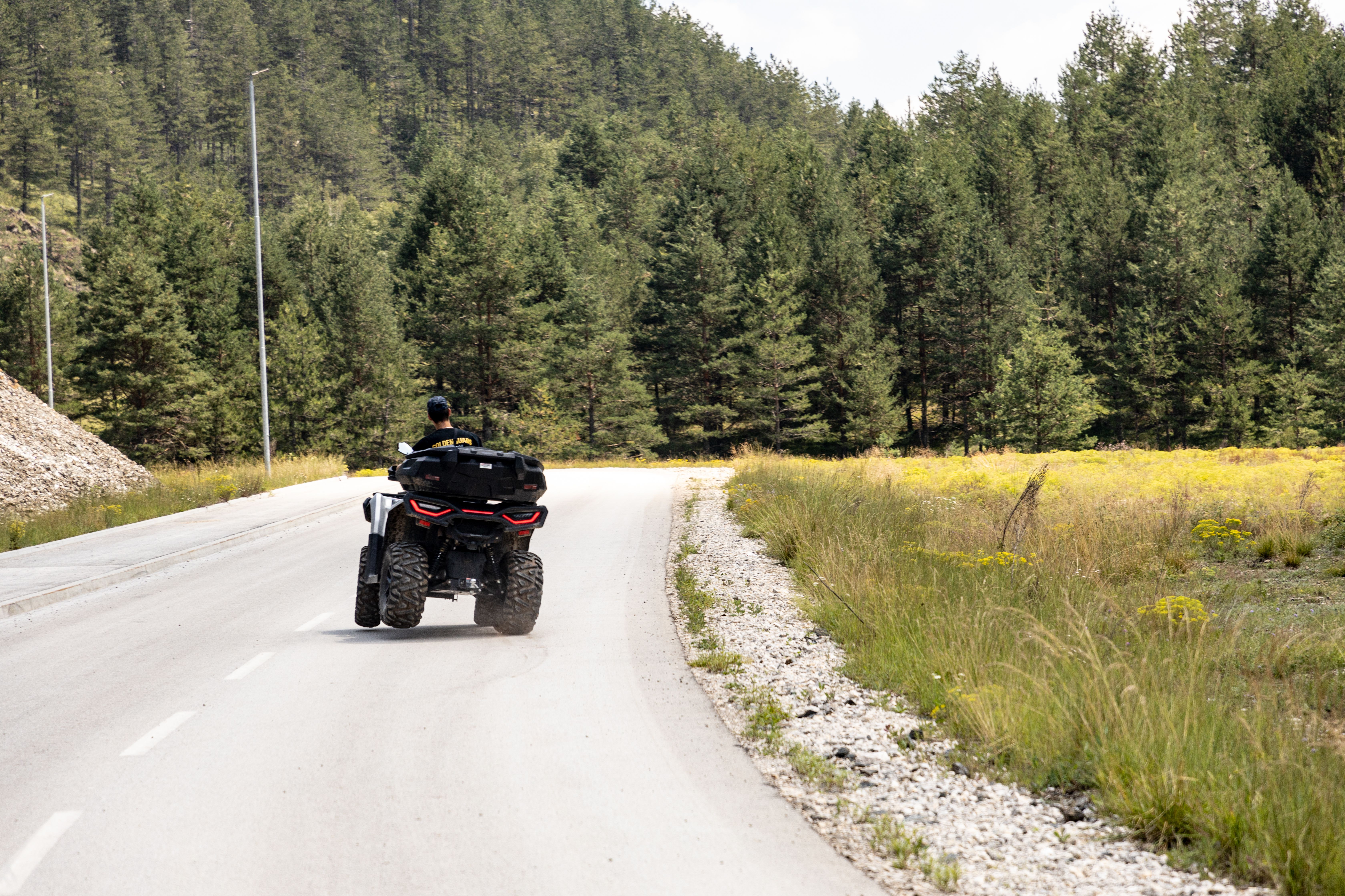 A solitary adventure on an ATV down a winding forest road in Zlatibor, Serbia.