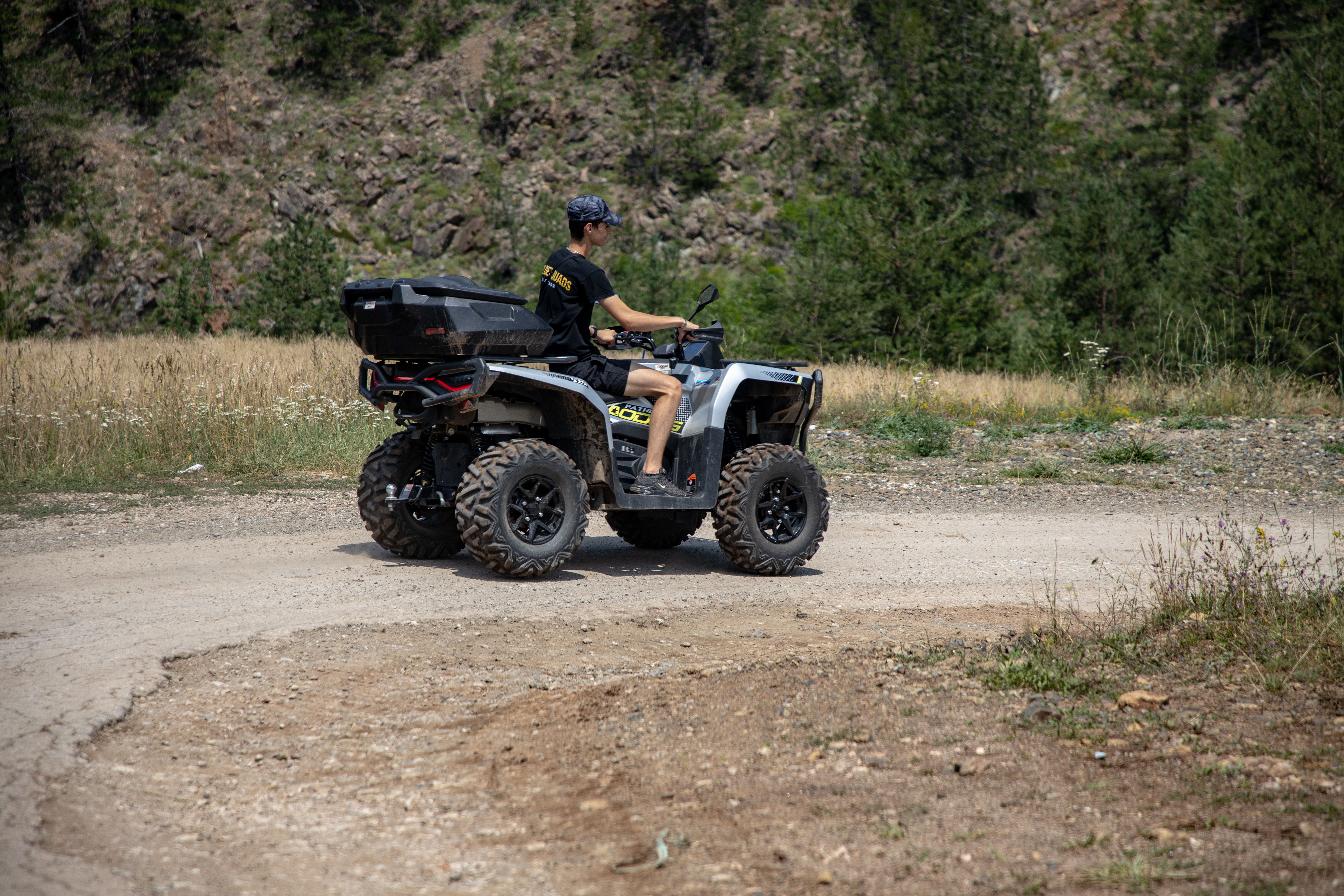 A person riding an ATV on a dirt path in Zlatibor, Serbia, surrounded by nature.