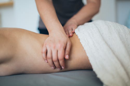 Free Person Lying in Bed Getting Massage Stock Photo