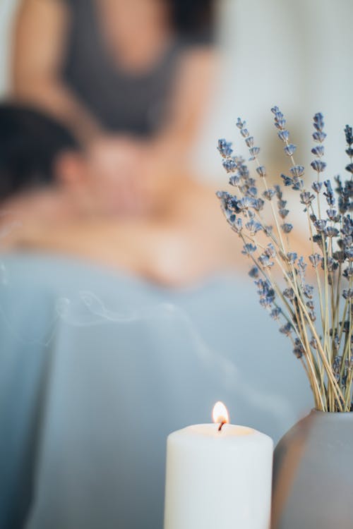 Free Lavender Flowers And Lighted Candle Stock Photo