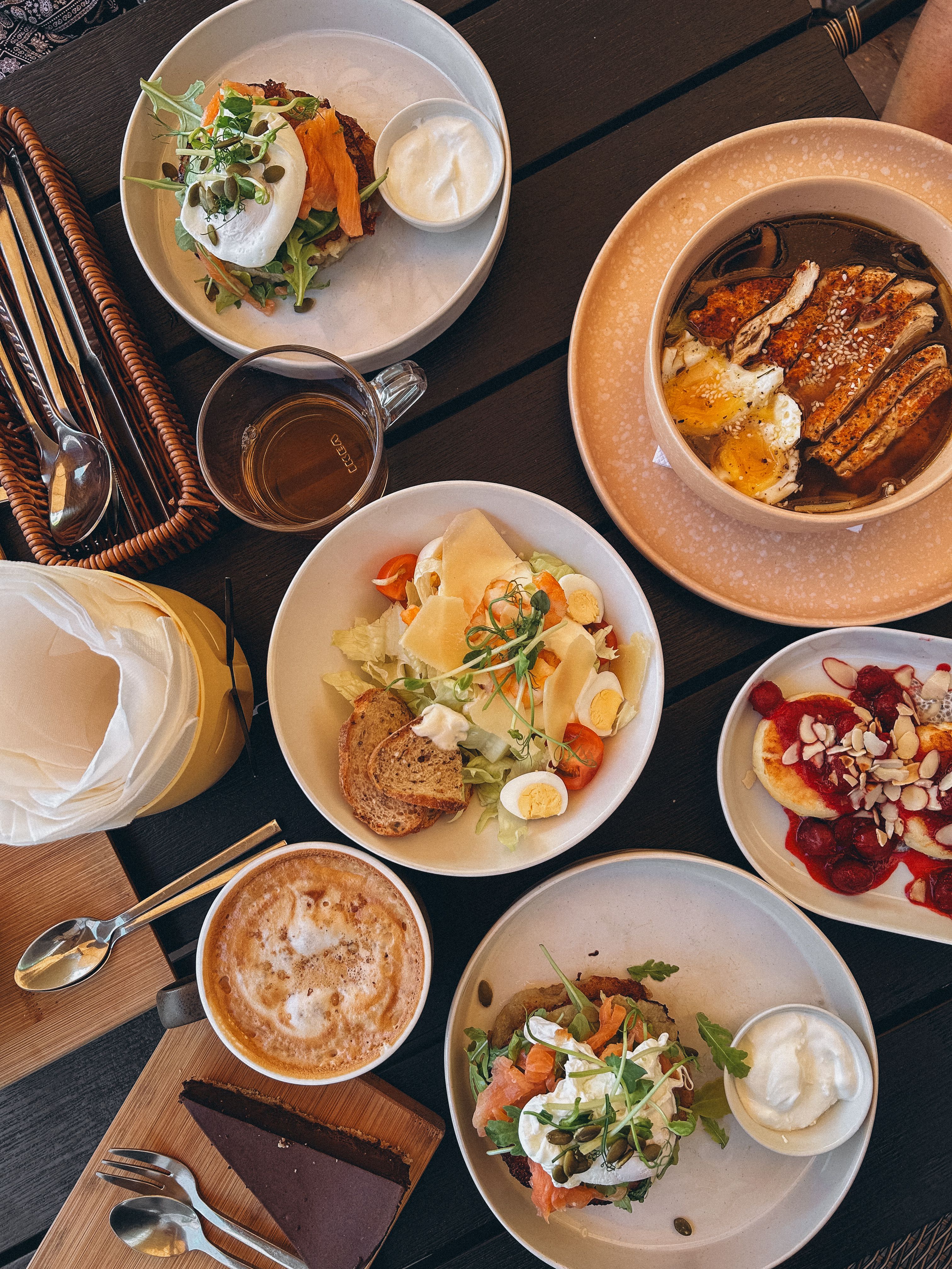 Flat lay of various brunch dishes including sandwiches, salads, and coffee, perfect for food enthusiasts.