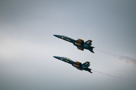 Two US Navy Blue Angels jets flying in formation against a clear sky., free online jigsaw puzzle on JigsawPuzzlesFreeOnline.org