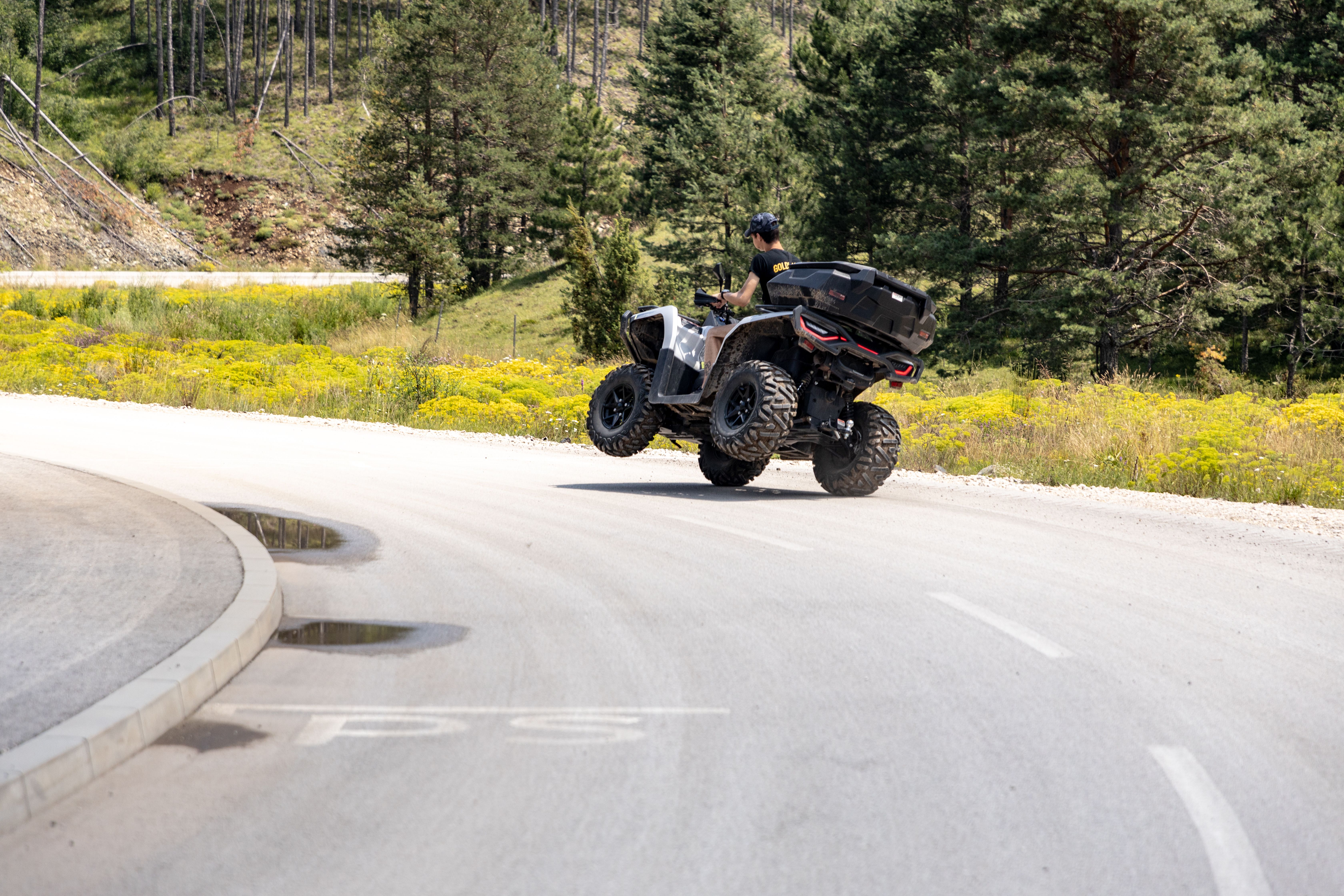 A thrilling moment as an ATV rider maneuvers through a scenic mountain road in Zlatibor, Serbia.