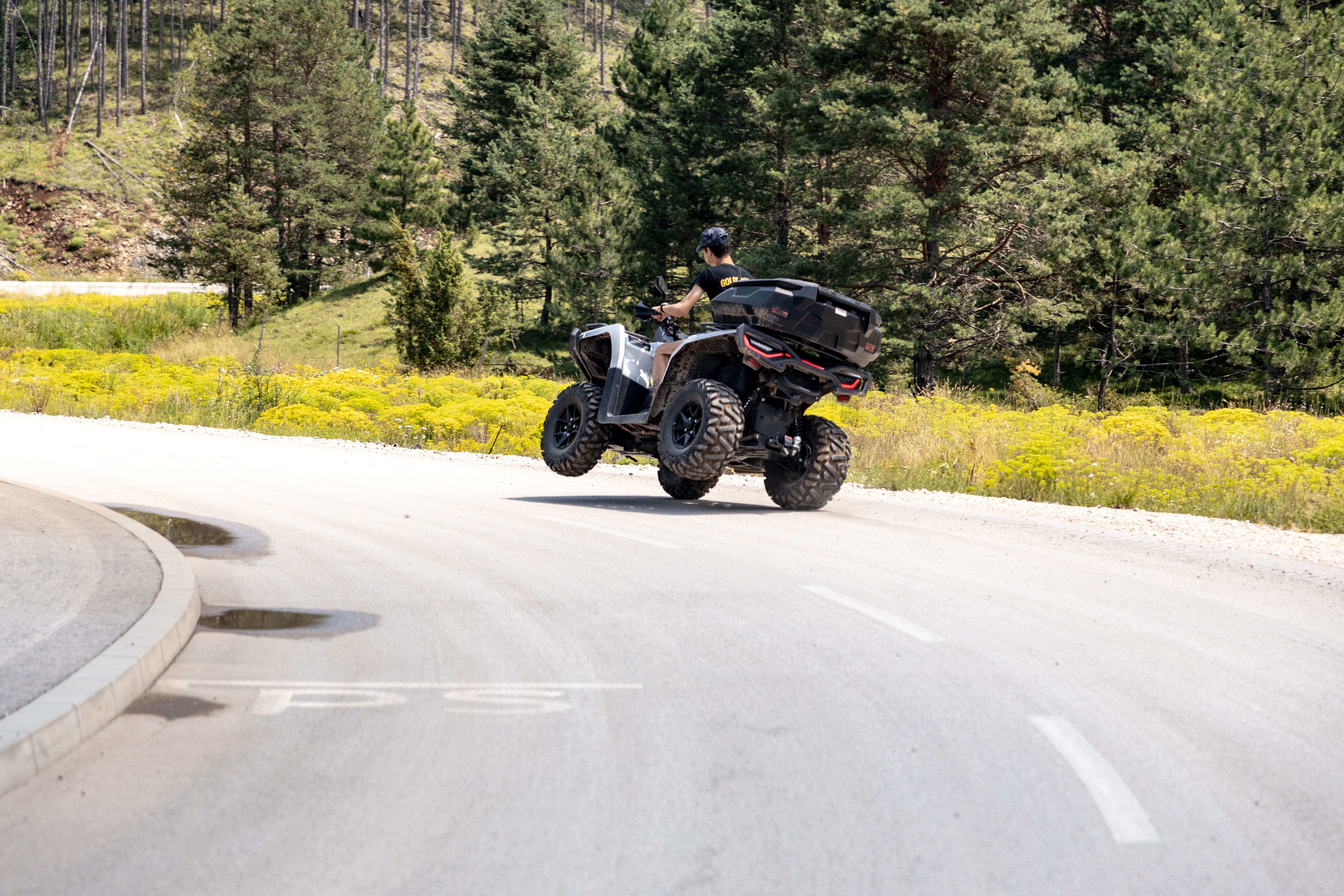 An adventurous ride on an ATV through a scenic road in Zlatibor, Serbia, surrounded by lush forests.