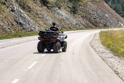 Free A person rides an ATV on a scenic mountain road in Zlatibor, Serbia, surrounded by rocky landscapes. Stock Photo
