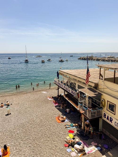 Free Relaxing day on a Mediterranean beach with a lively snack bar and people enjoying the sun and sea. Stock Photo