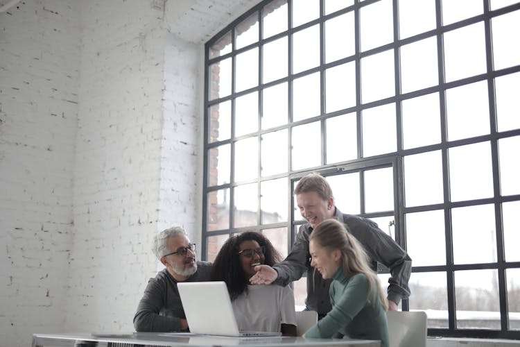 Excited Diverse Colleagues Of Different Ages Working On Laptop During Startup Project