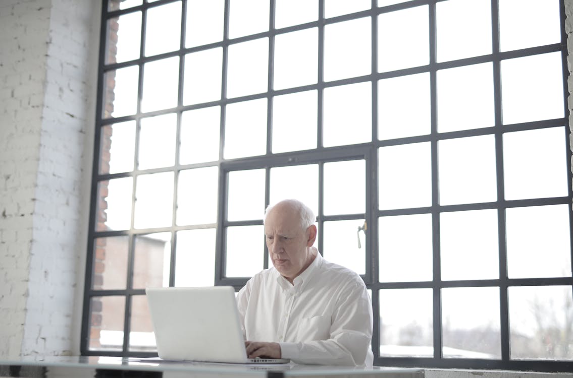 Free Man in White Shirt Sitting in Front of Macbook Stock Photo