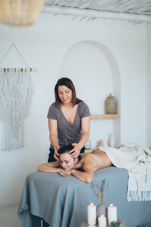 Free  A Massage Therapist Massaging a Client's Head Stock Photo