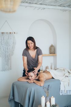 在宁静的水疗环境中，女士接受轻松的头部按摩，以促进健康和放松