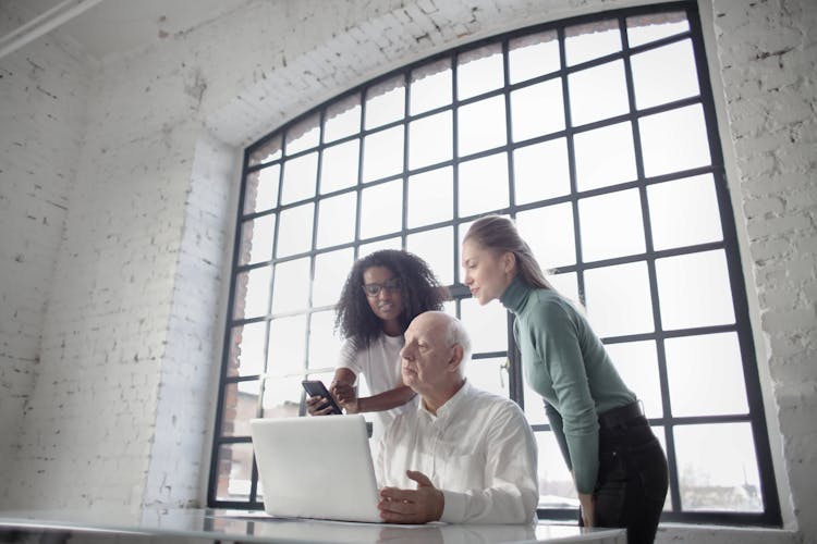 Concentrated Diverse Coworkers Of Different Age Discussing Job Project In Creative Workplace