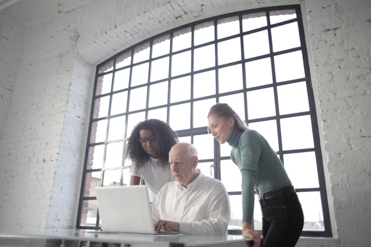 Focused Multiracial Coworkers Of Different Age Discussing Job Project In Creative Workplace