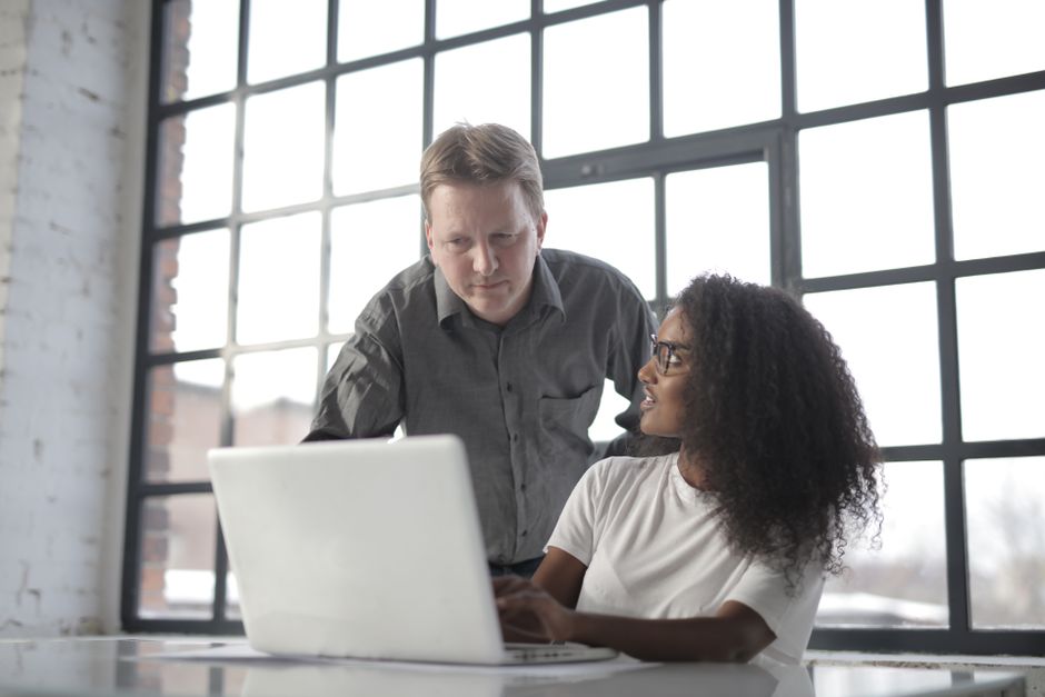 Experienced mentor guiding a colleague through a new CRM software interface - CRM change management Experienced mentor guiding a colleague through a new CRM software interface - CRM change management