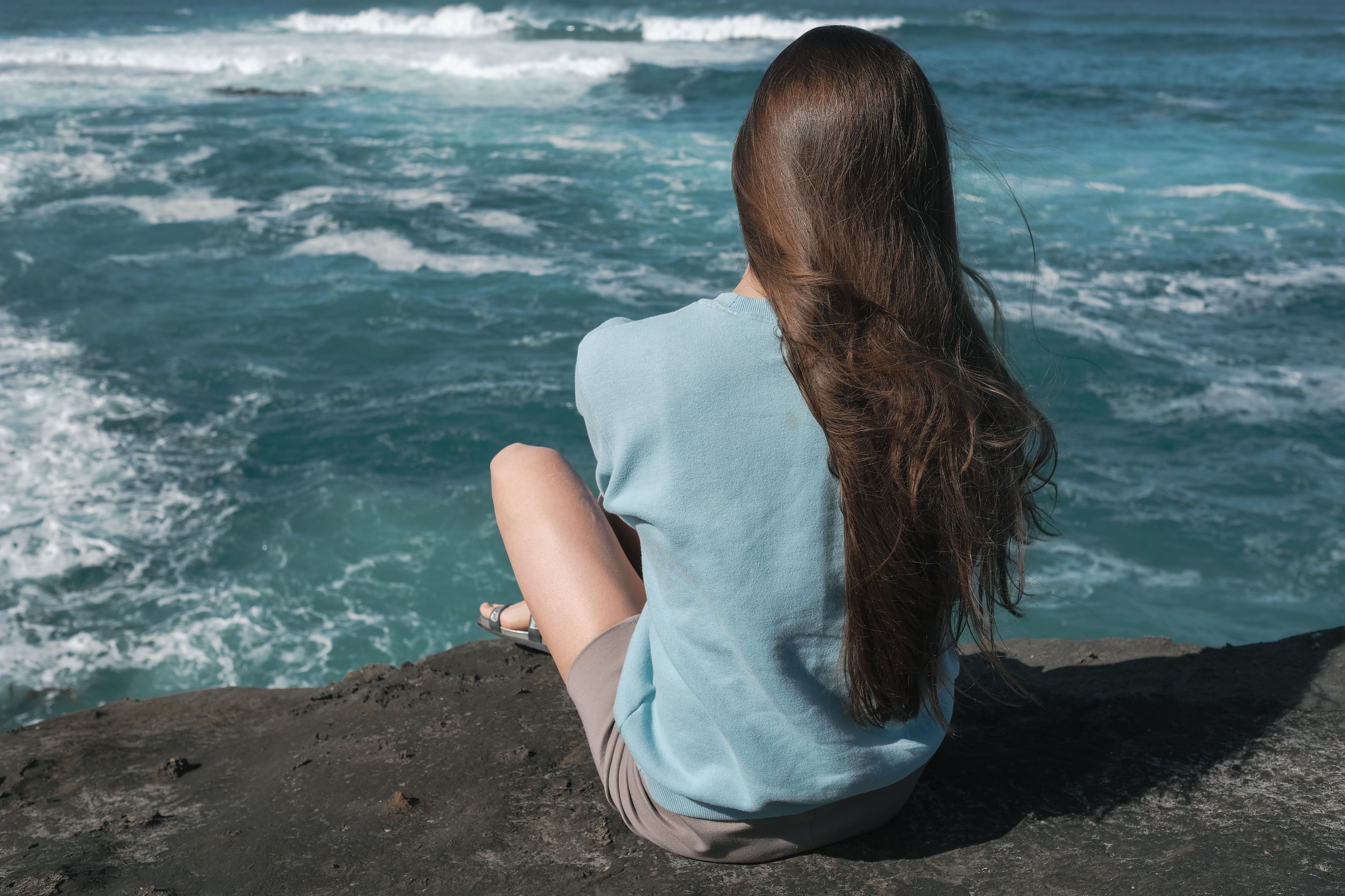 A Woman in Blue Shirt Sitting on the Cliff · Free Stock Photo