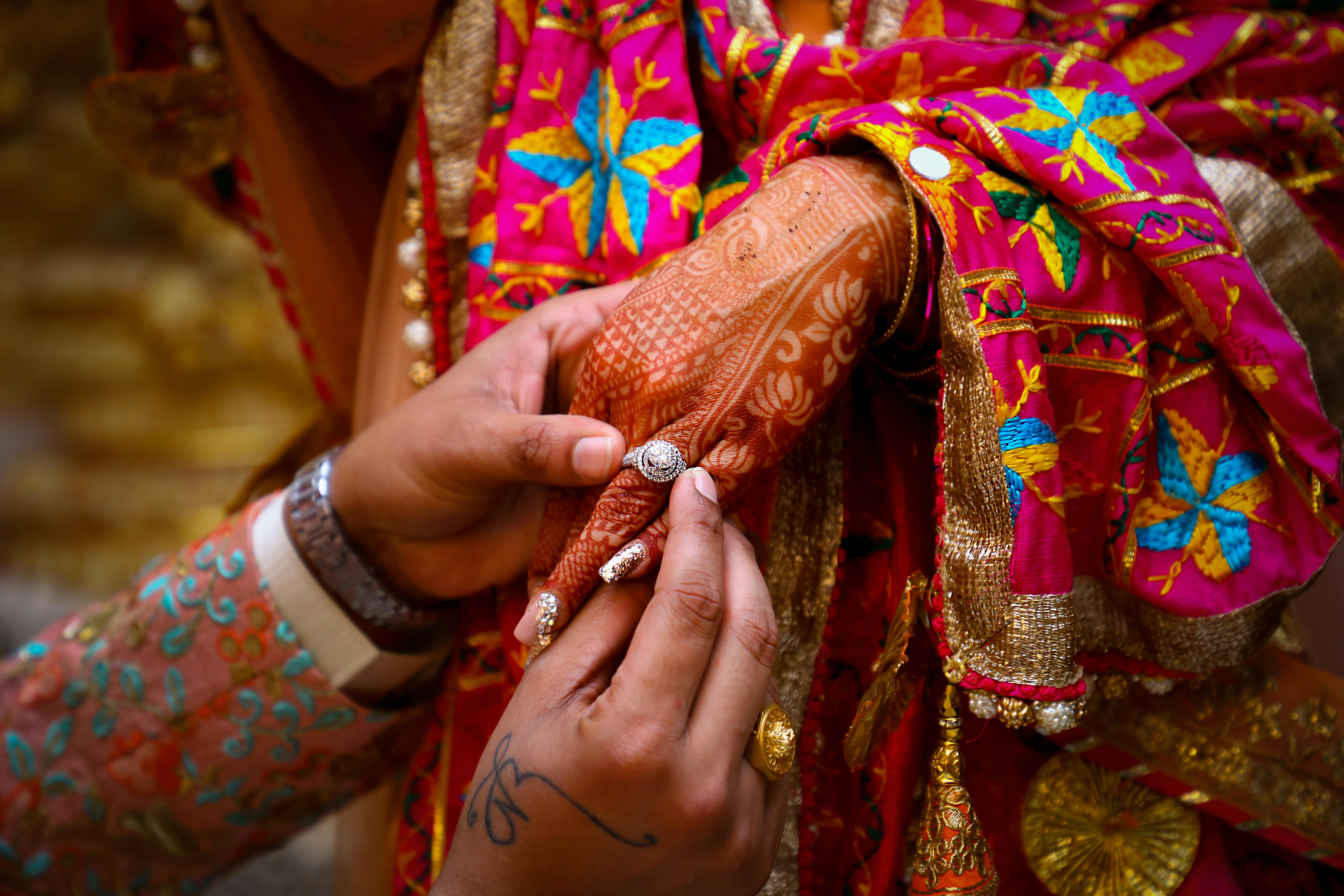 crop indian man giving ring to woman during traditional wedding ceremony