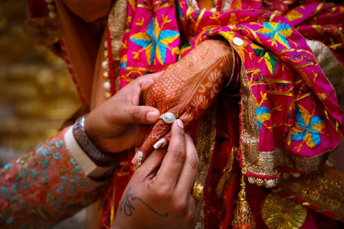 Crop Indian man giving ring to woman during traditional wedding ceremony