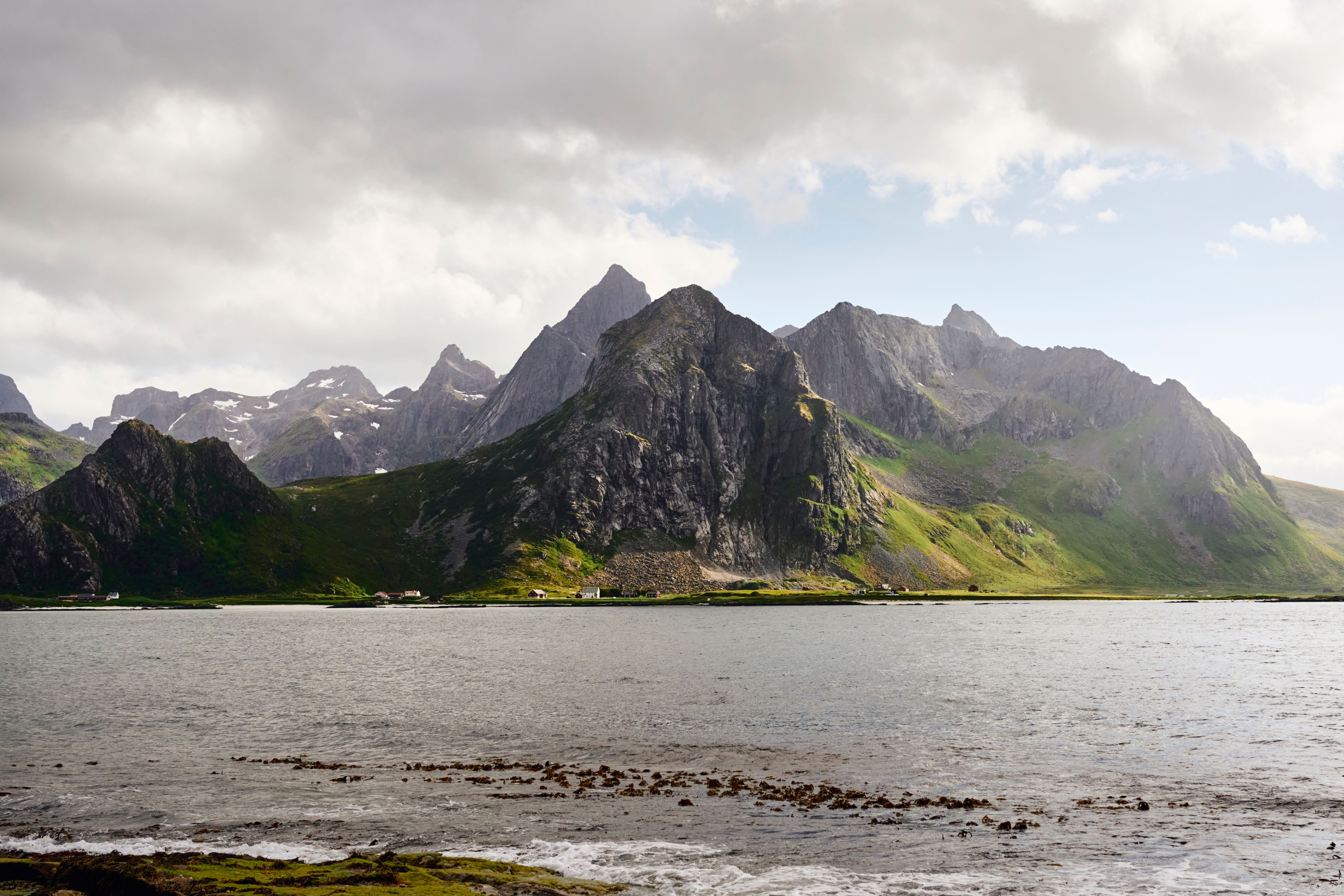 Captivating view of Lofoten Islands with lush green mountains and tranquil sea.