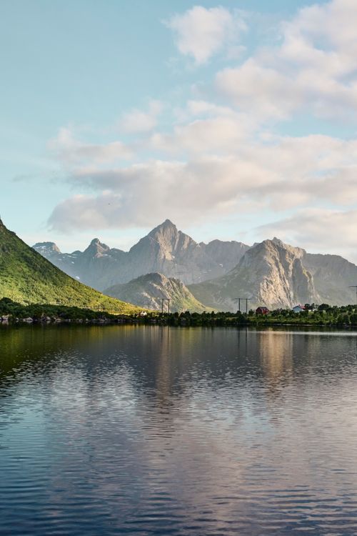 Free Breathtaking view of mountains reflecting in a serene lake under a blue sky. Stock Photo