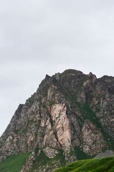 A striking view of a rocky mountain peak against a cloudy sky, showcasing natural beauty and rugged terrain.