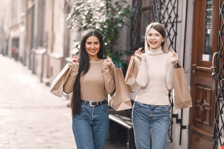 Happy Young Women With Shopping Bags Walking On Street