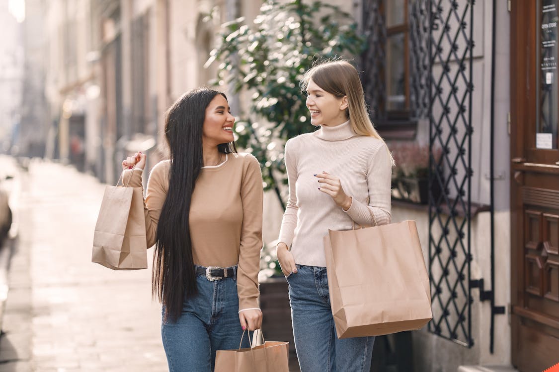 Cheerful friends carrying shopping bags and smiling