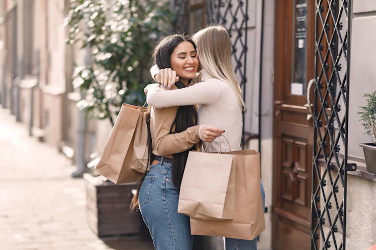 Happy Friends Hugging After Shopping On Street