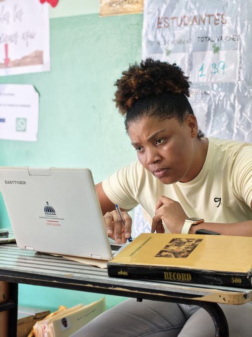 Free Woman concentrating intently on a task using a laptop in a classroom setting. Stock Photo