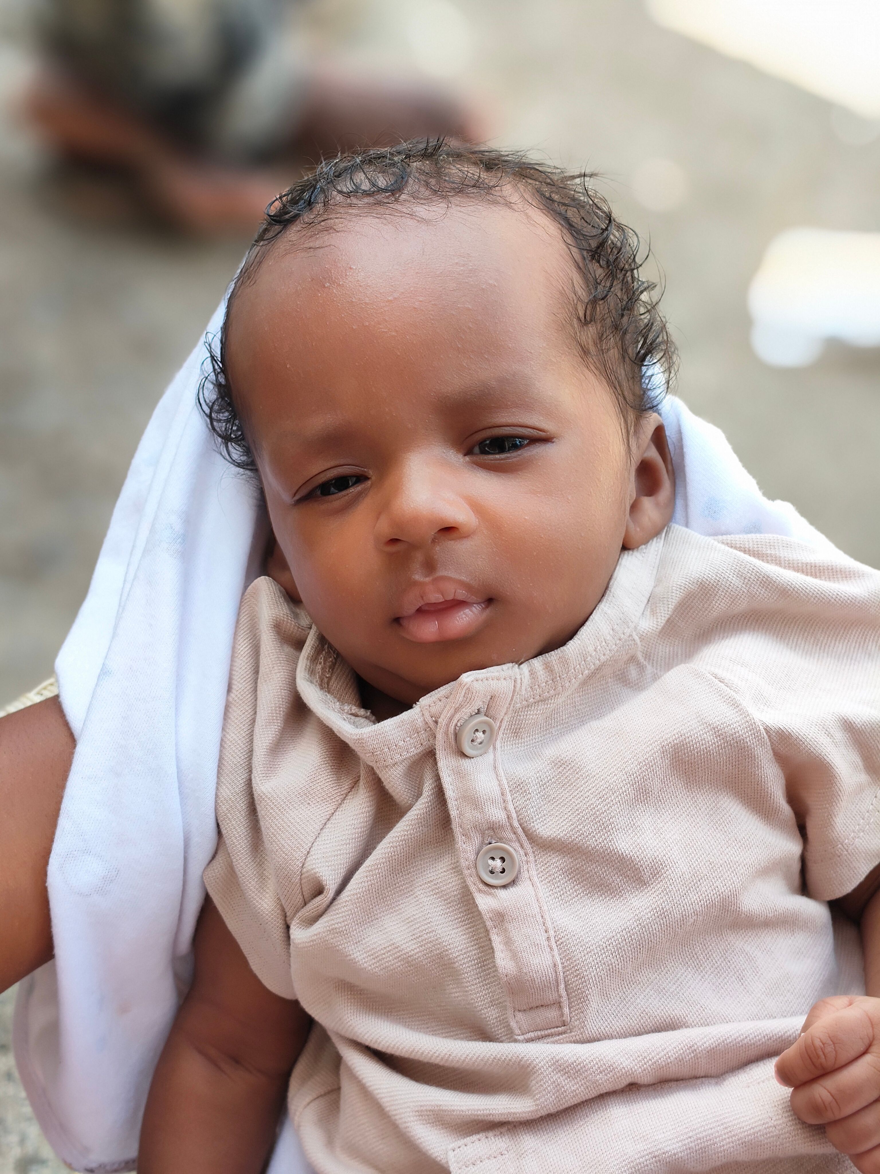 Charming portrait of a baby outdoors in natural light. Perfect for lifestyle or family themes.