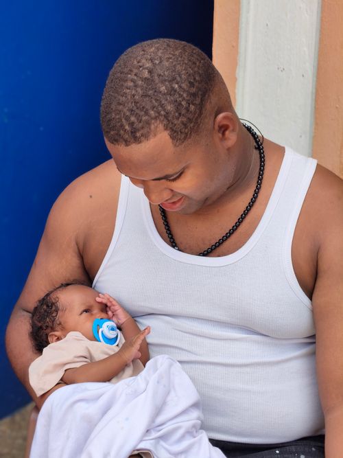 Free A tender moment captured between a father and his newborn baby outdoors. Stock Photo