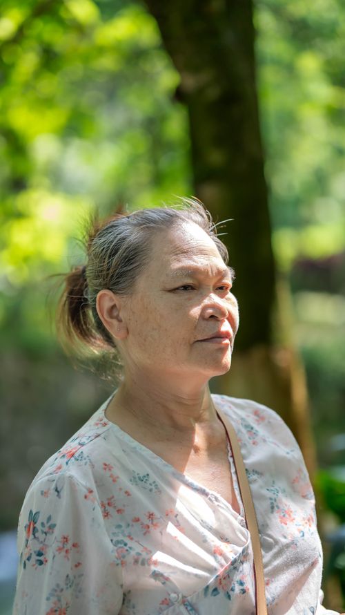 Free Serene portrait of a senior woman enjoying a sunny day outdoors. Stock Photo
