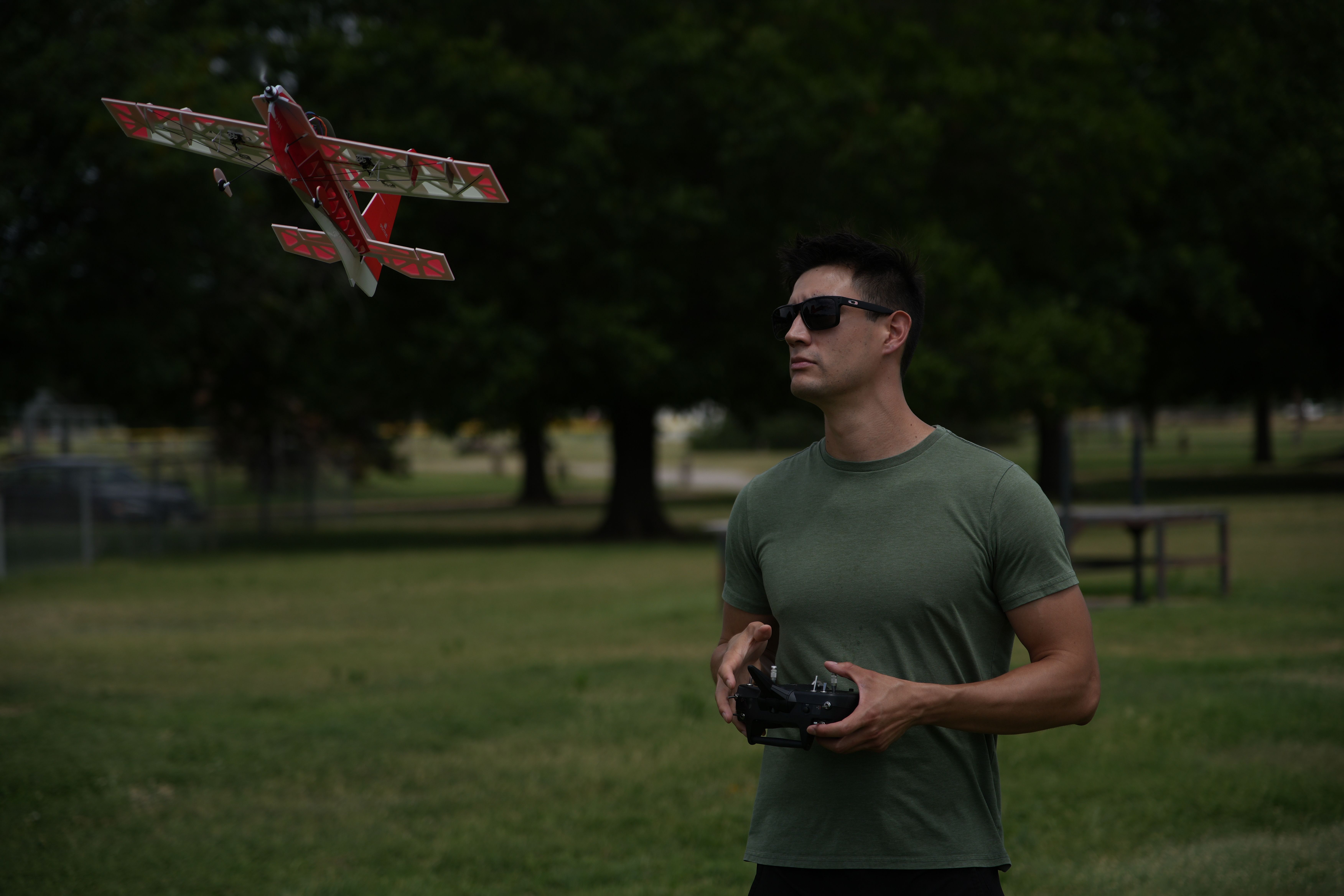 A man controls a remote control plane in a sunny Wichita Falls park.