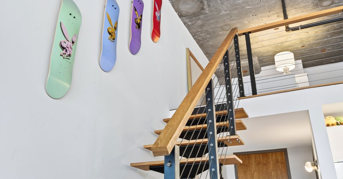 Stylish loft in Boston featuring a modern industrial staircase and skateboard art decor.