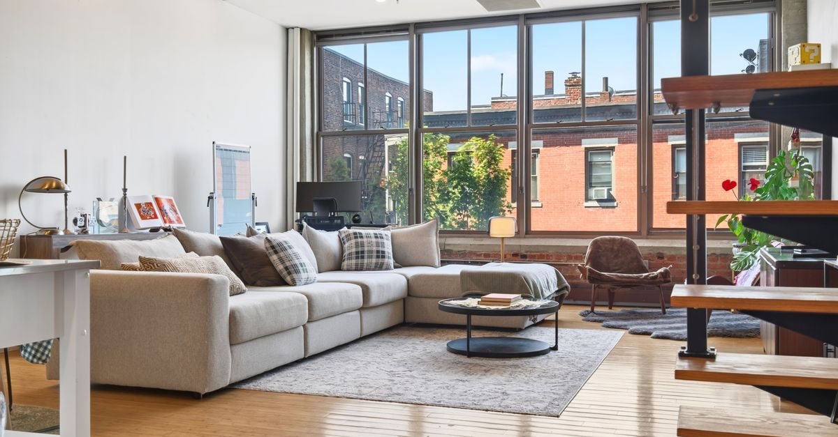 Bright and spacious industrial-style loft in Boston with large windows and modern furnishings.