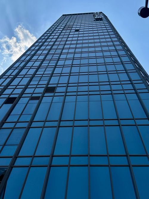 Free A dramatic low-angle view of a modern skyscraper against a clear sky in Chongqing, China. Stock Photo