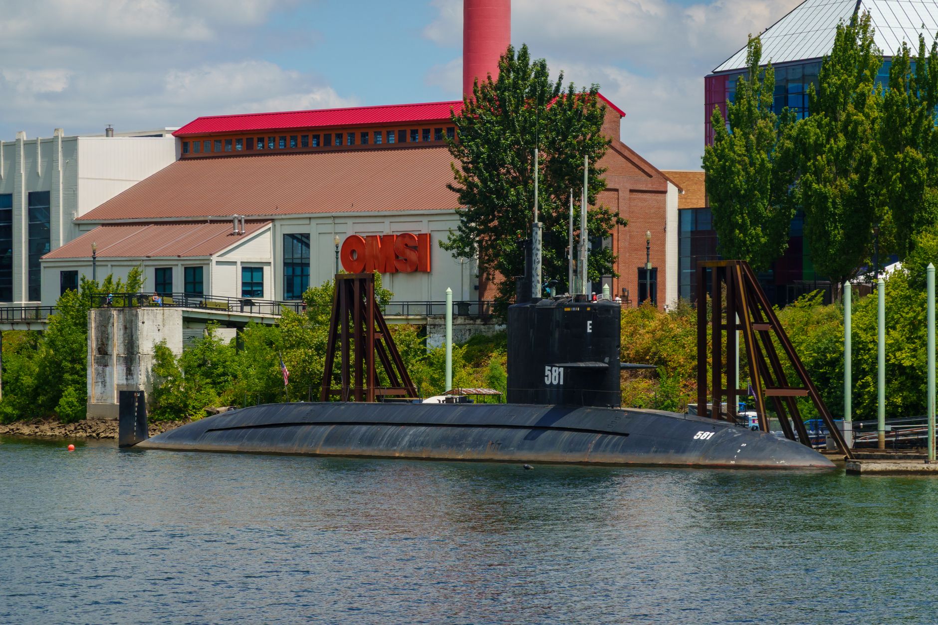 Submarine docked at OMSI with industrial background in Portland.