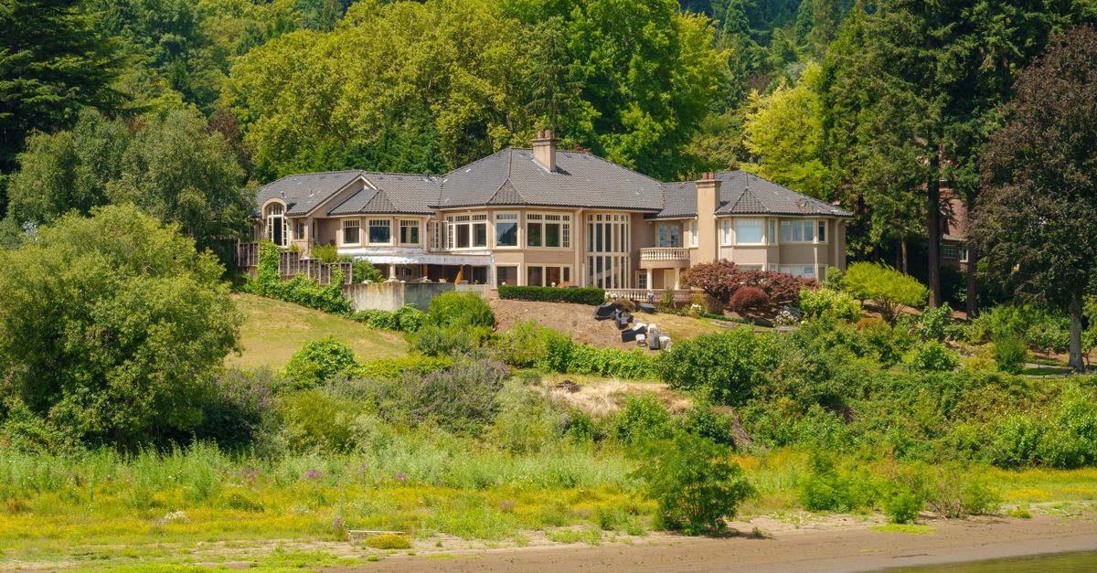 A beautiful luxury home by the water with lush forest surroundings in spring.
