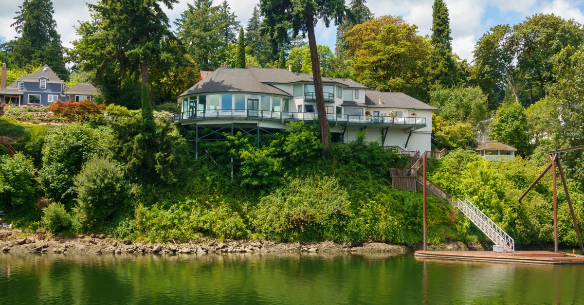 A stunning lakeside house amidst vibrant greenery, perfect for tranquil living.