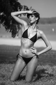 Fashion model posing outdoors in a bikini, stylish black and white photo.