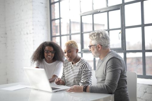 Free Concentrated freelancer in informal outfit discussing project while working remotely and surfing laptop in light coffee shop at daytime Stock Photo